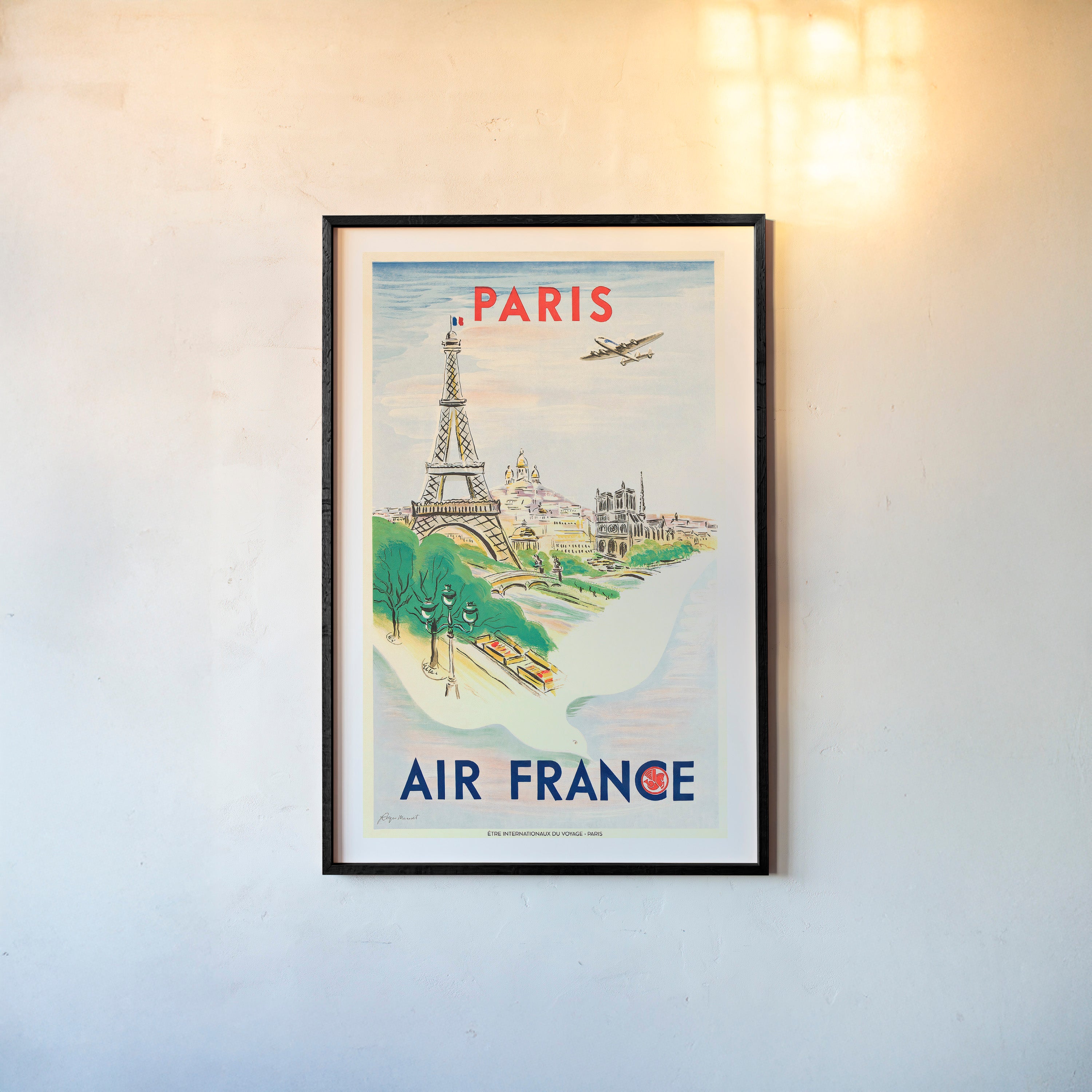 Framed Air France poster of Paris on a wall