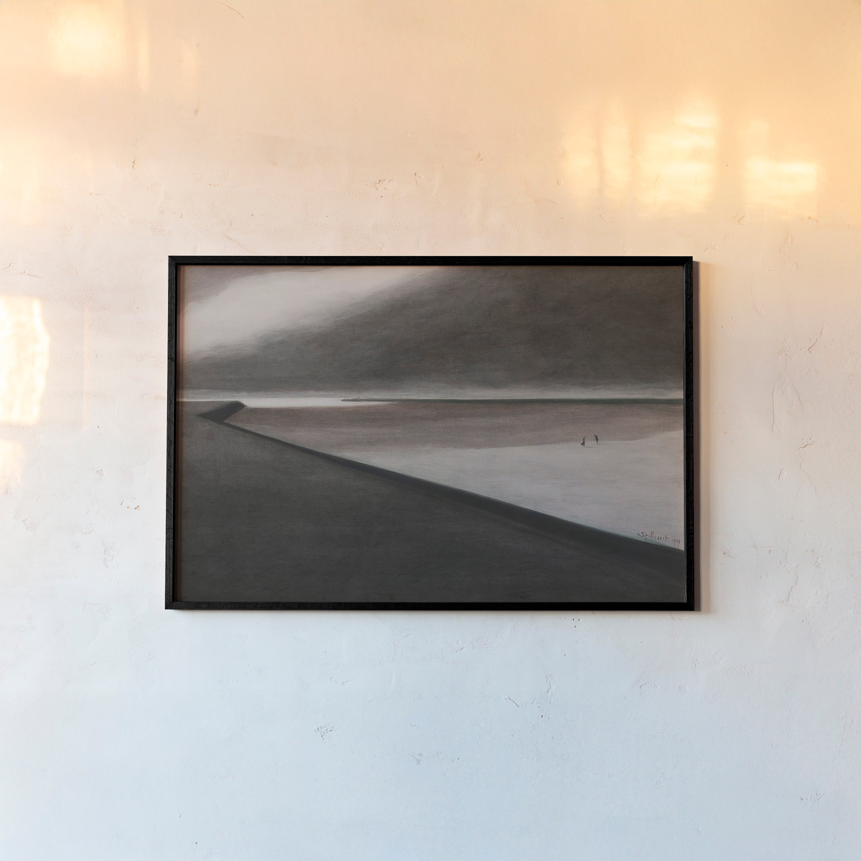 Framed poster of a dark beach scene hanging on a light background