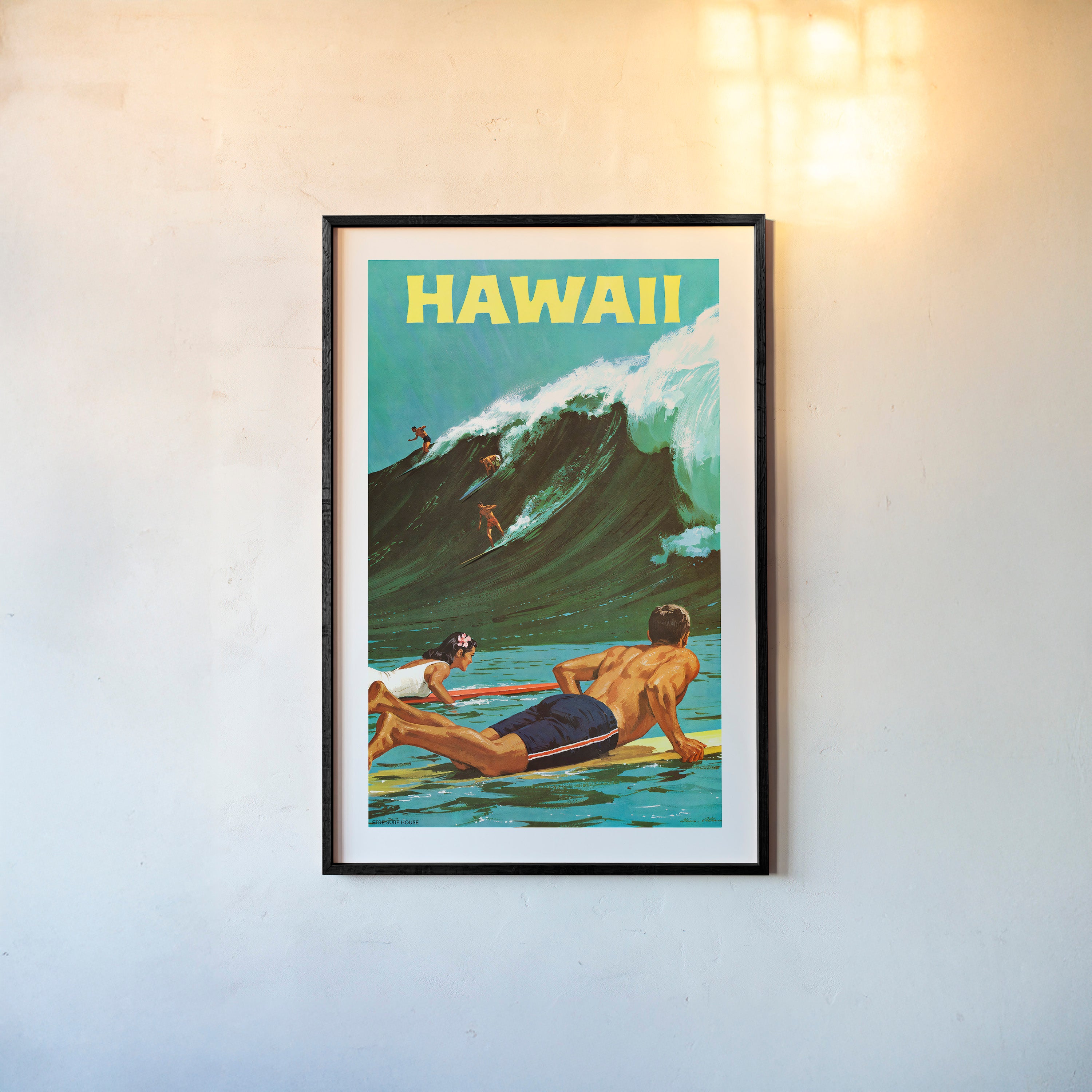 Framed "Hawaii" poster featuring surfers on a big wave hanging on a light background