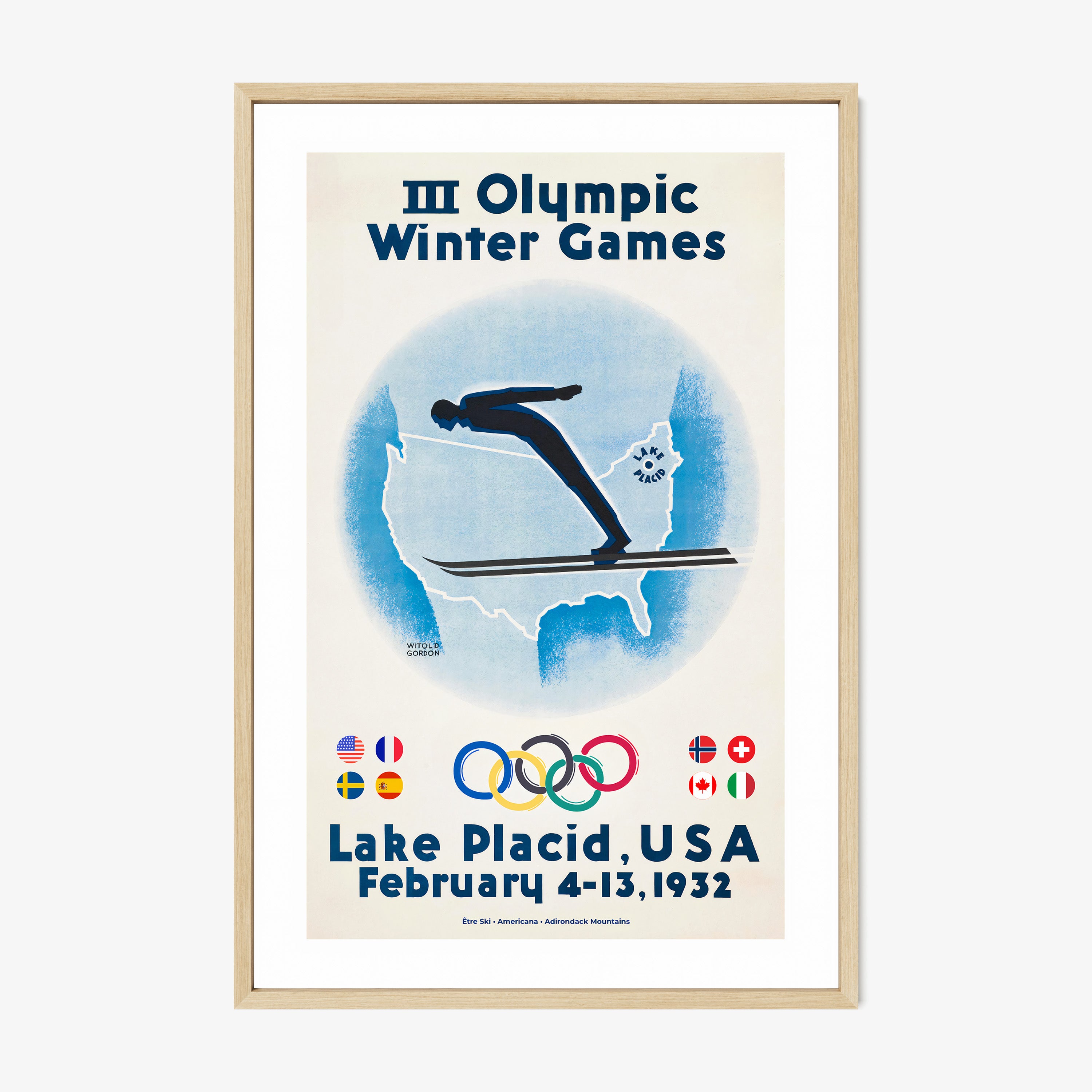 Framed poster of a skier with the United States map in the background and information on the 1932 Lake Placid winter olympic games hanging on a wall with a light background