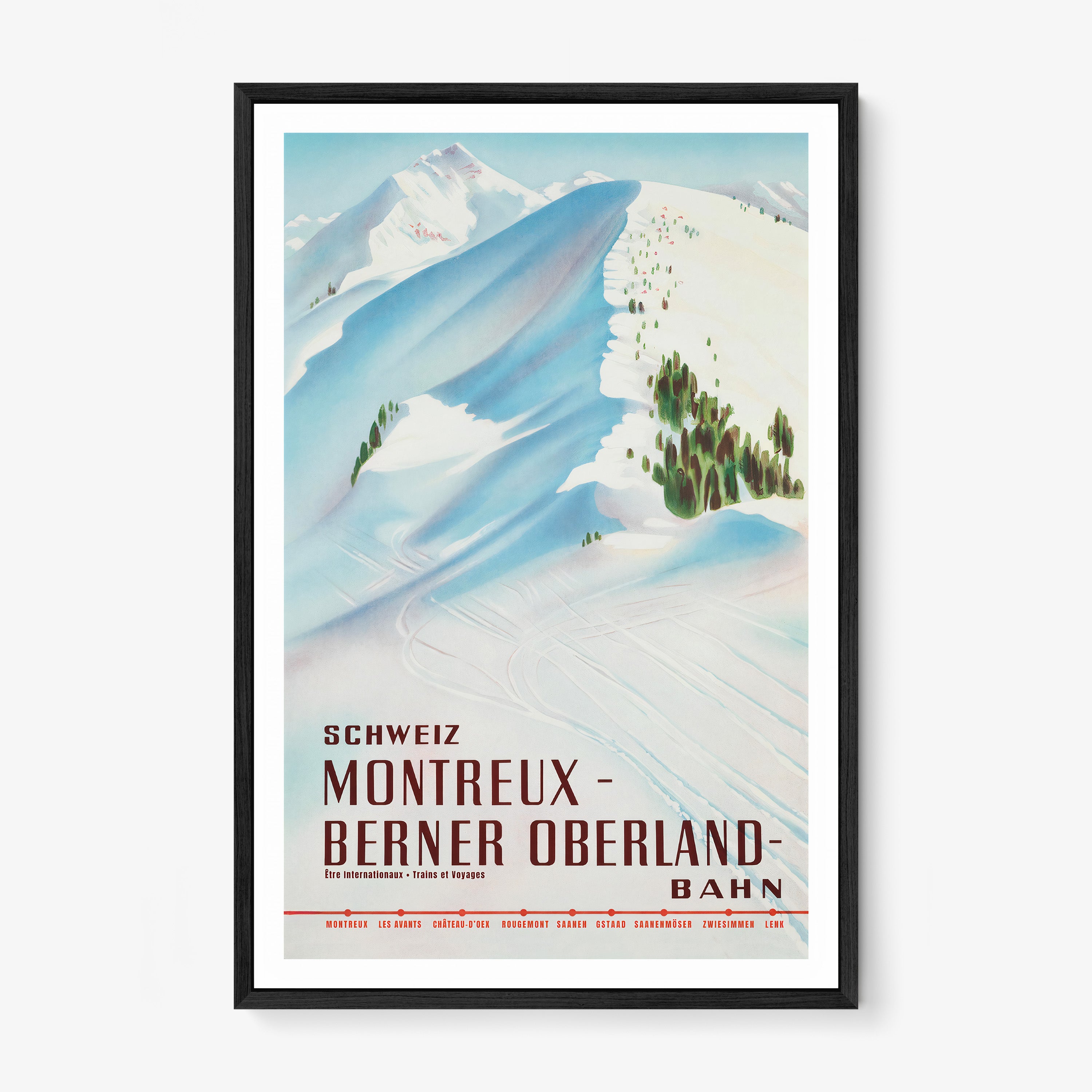 Framed poster featuring a snow covered mountain with the text "Montreux- Berner Oberland" at the bottom hanging on a white background