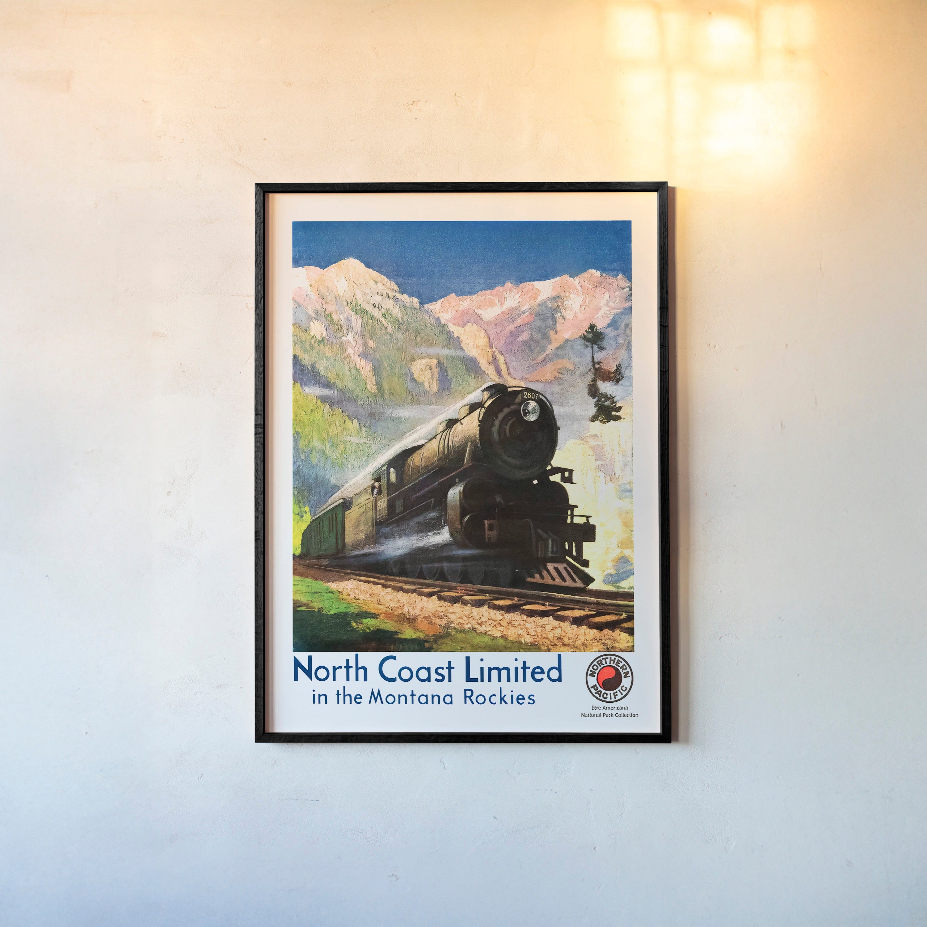 Framed poster of a train speeding through a mountain scene hanging on a light background