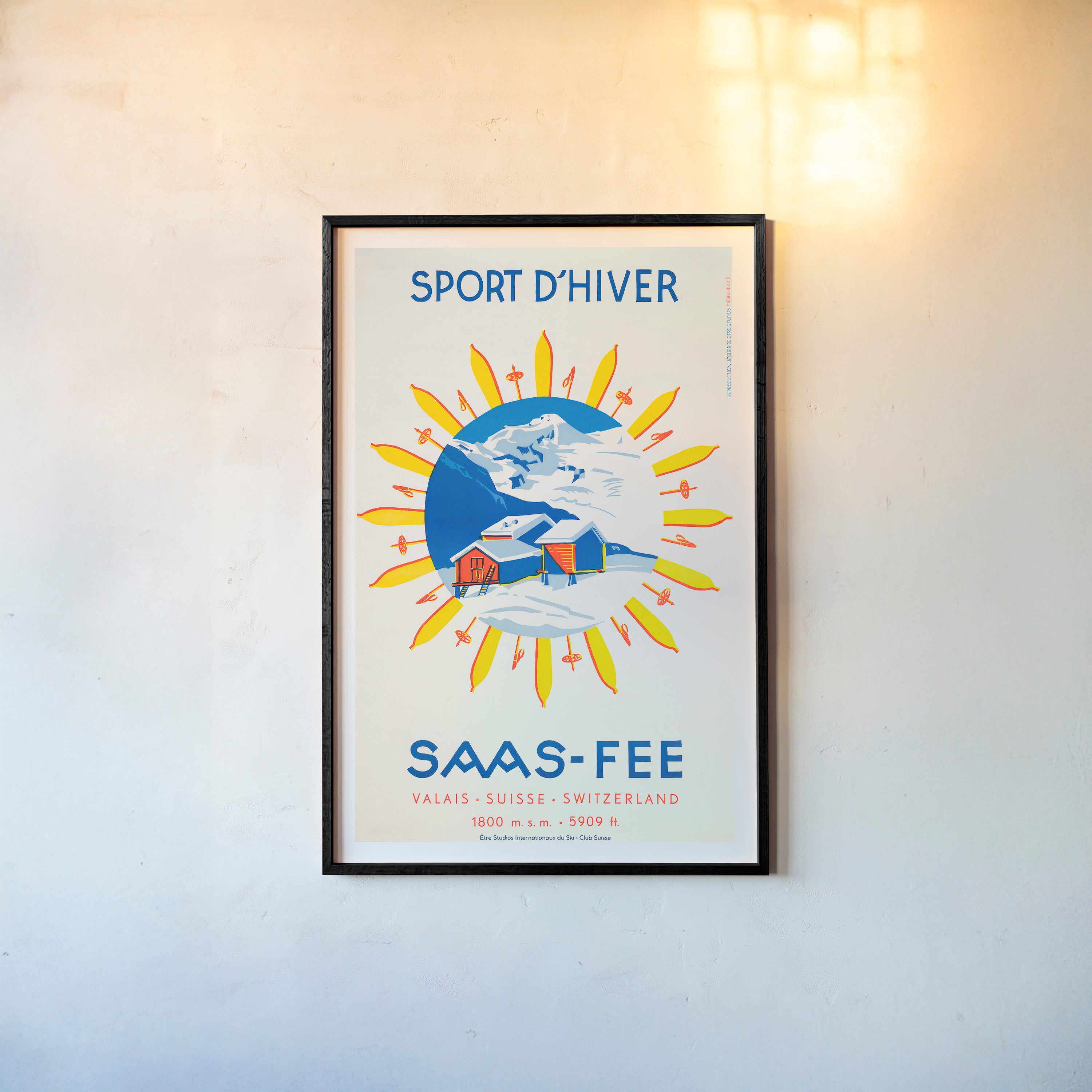Framed poster of 'Sport d'Hiver Saas-Fee' on a wall.