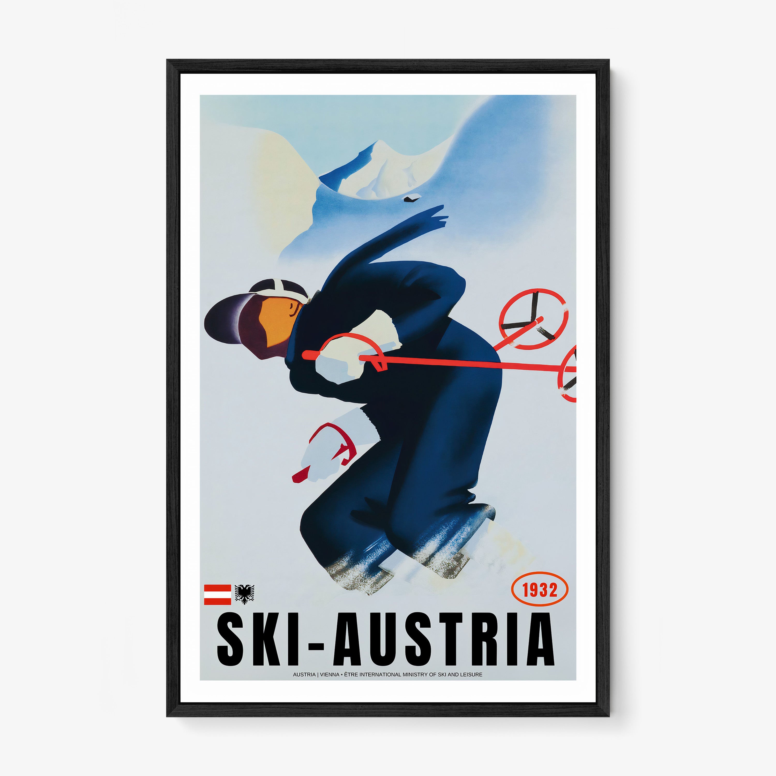 Framed poster of a skier with the text "Ski-Austria" at the bottom hanging on a light backdrop