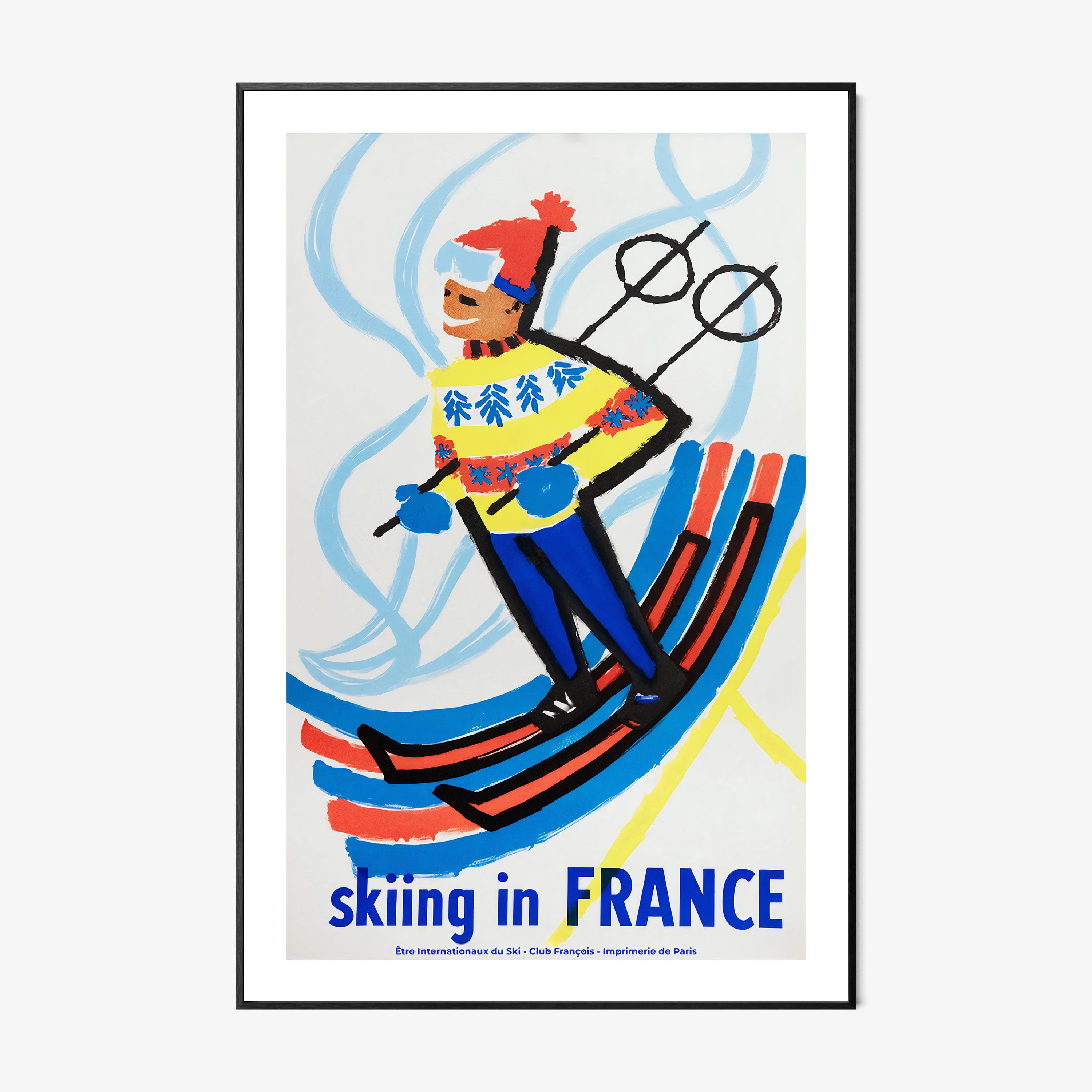 Framed poster of a skier with 'Skiing in France' text on a wall.