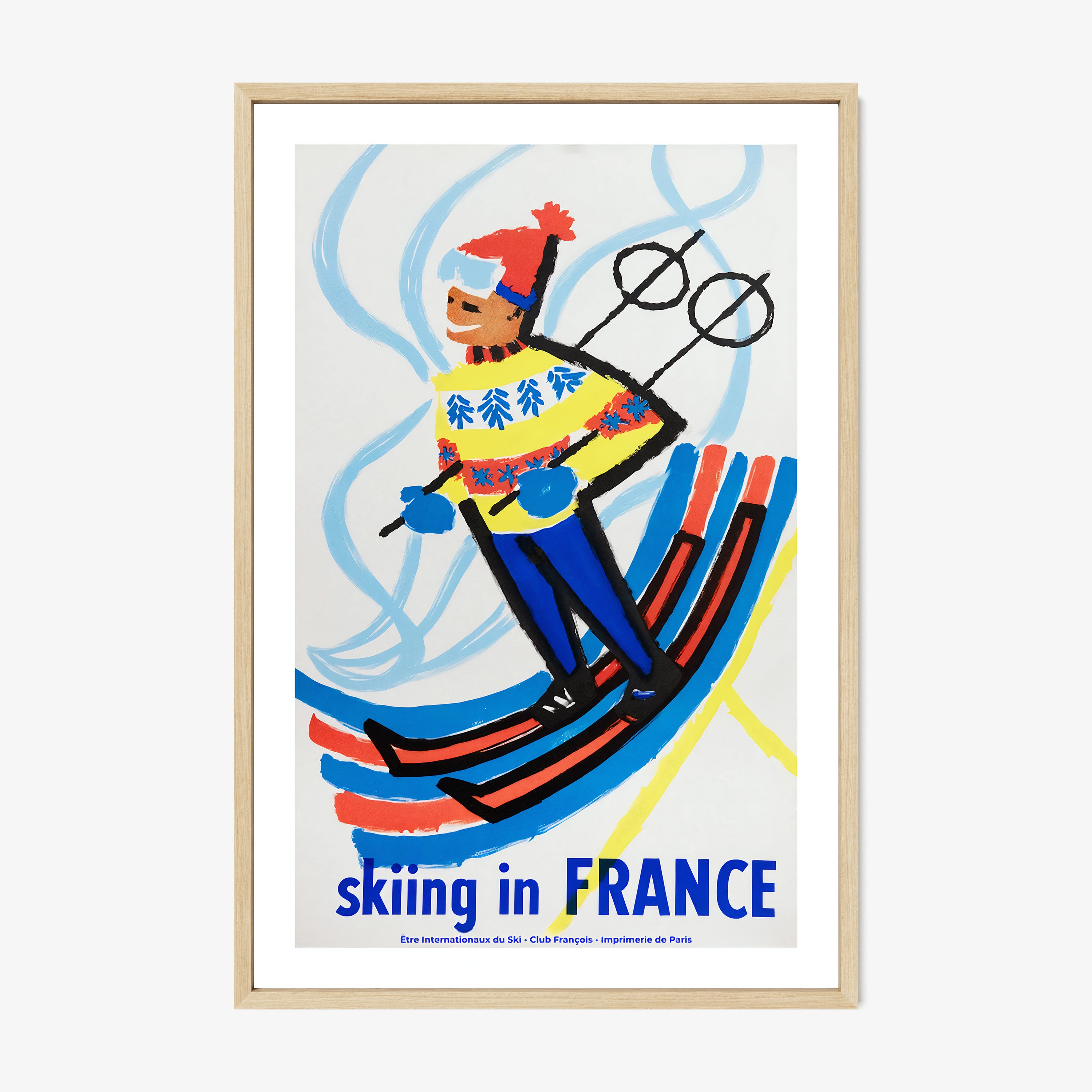 Framed poster of a skier with 'Skiing in France' text on a wall.