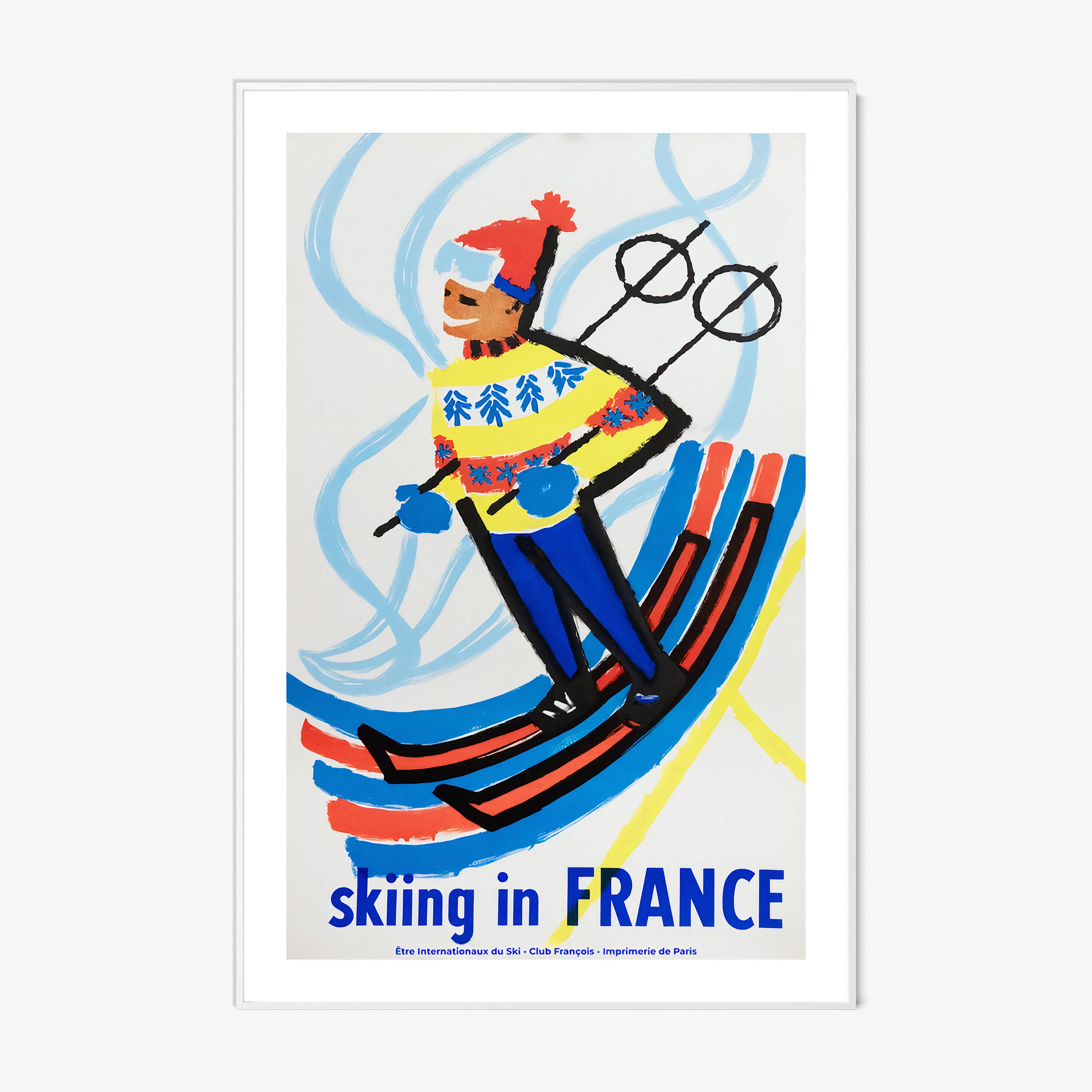 Framed poster of a skier with 'Skiing in France' text on a wall.