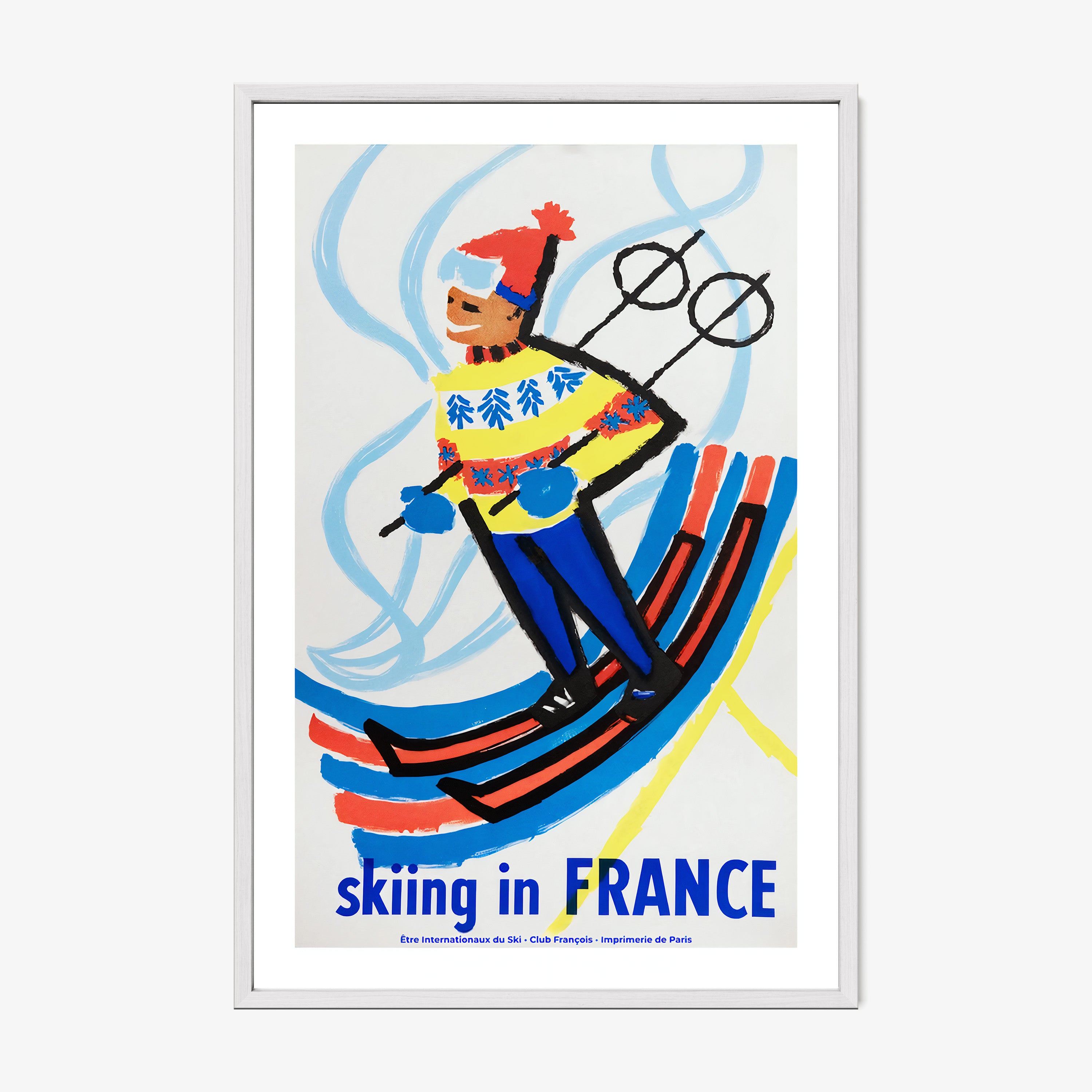 Framed poster of a skier with 'Skiing in France' text on a wall.