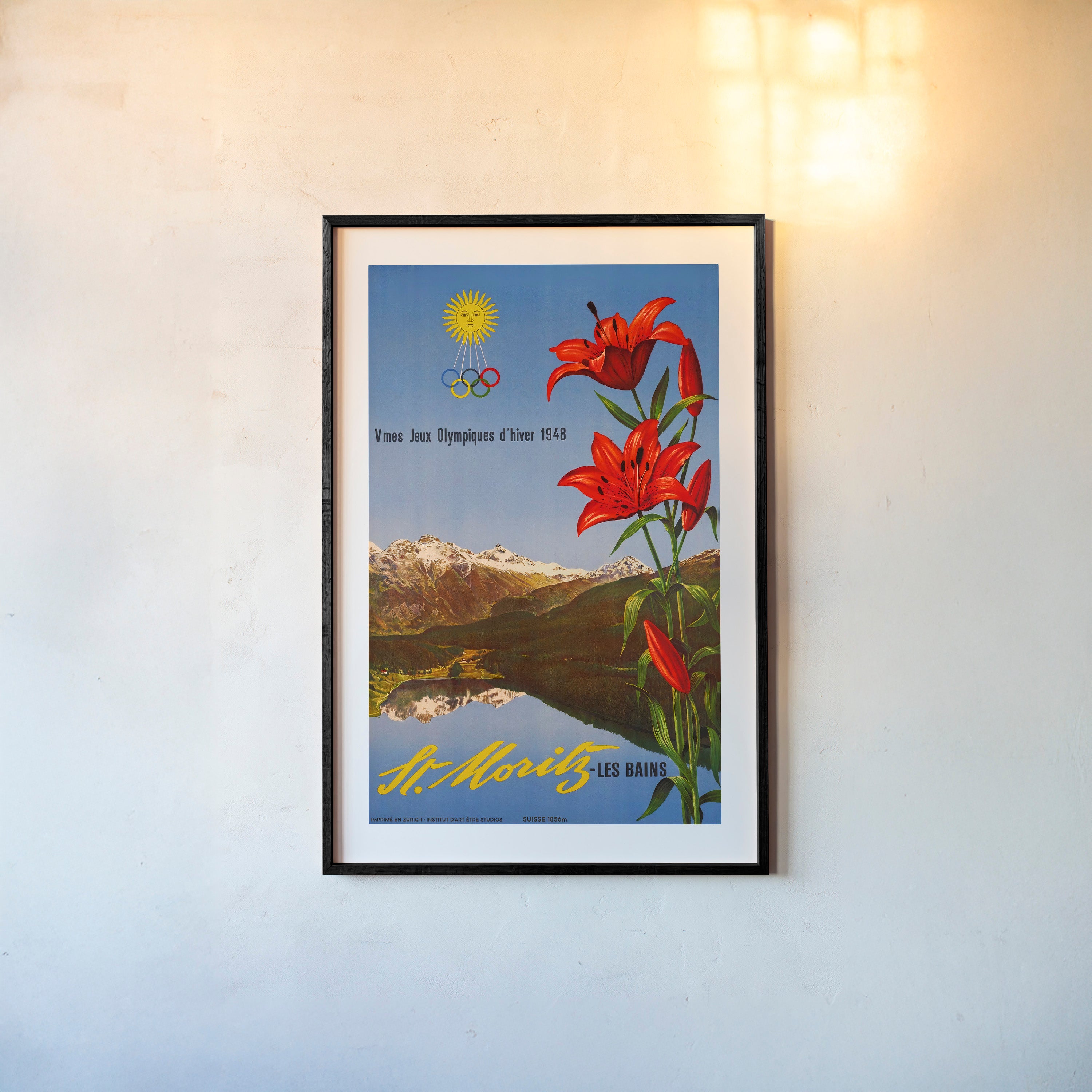 Framed poster with red flowers and mountain landscape on a wall.