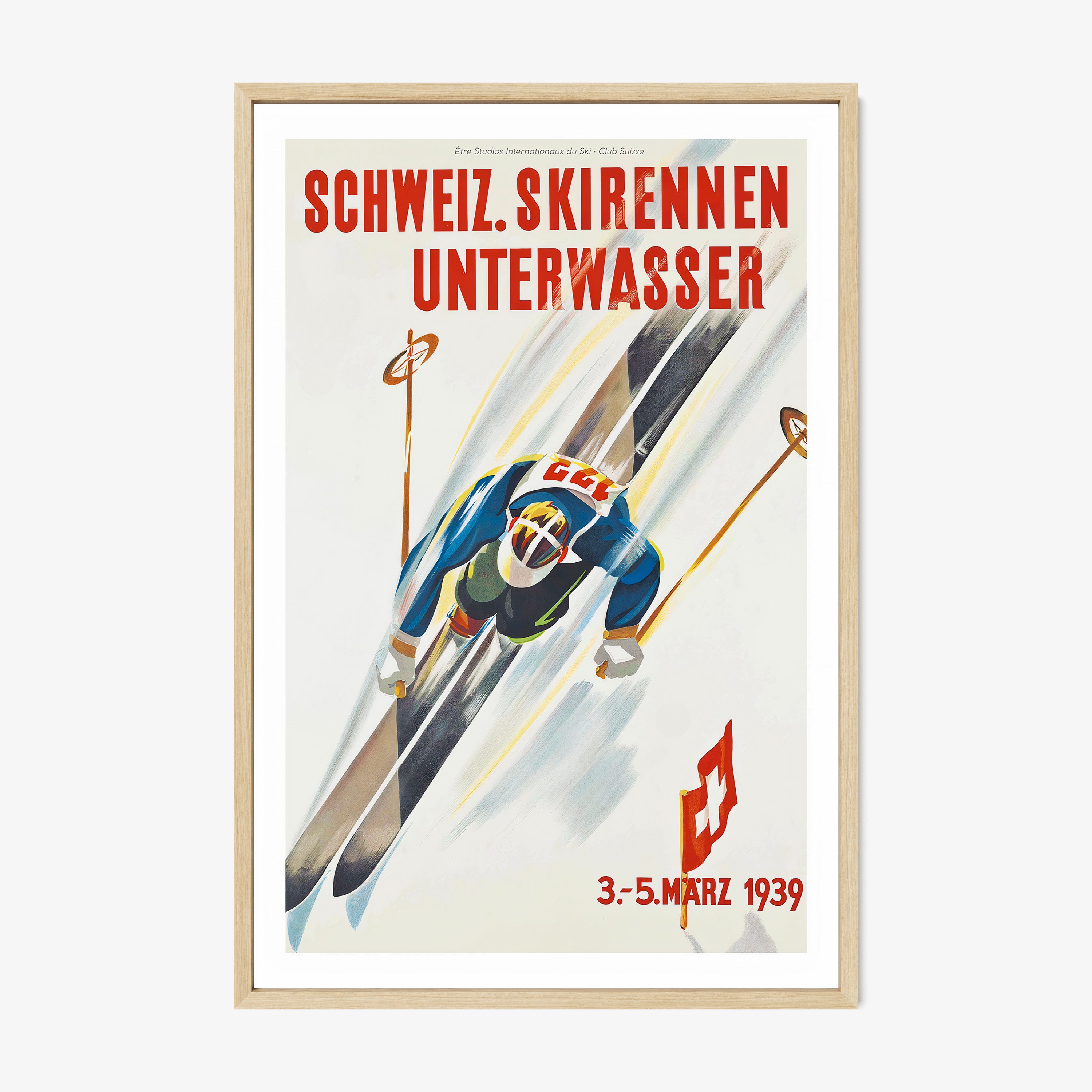 Framed poster of a skier taken from above hanging on a light backdrop
