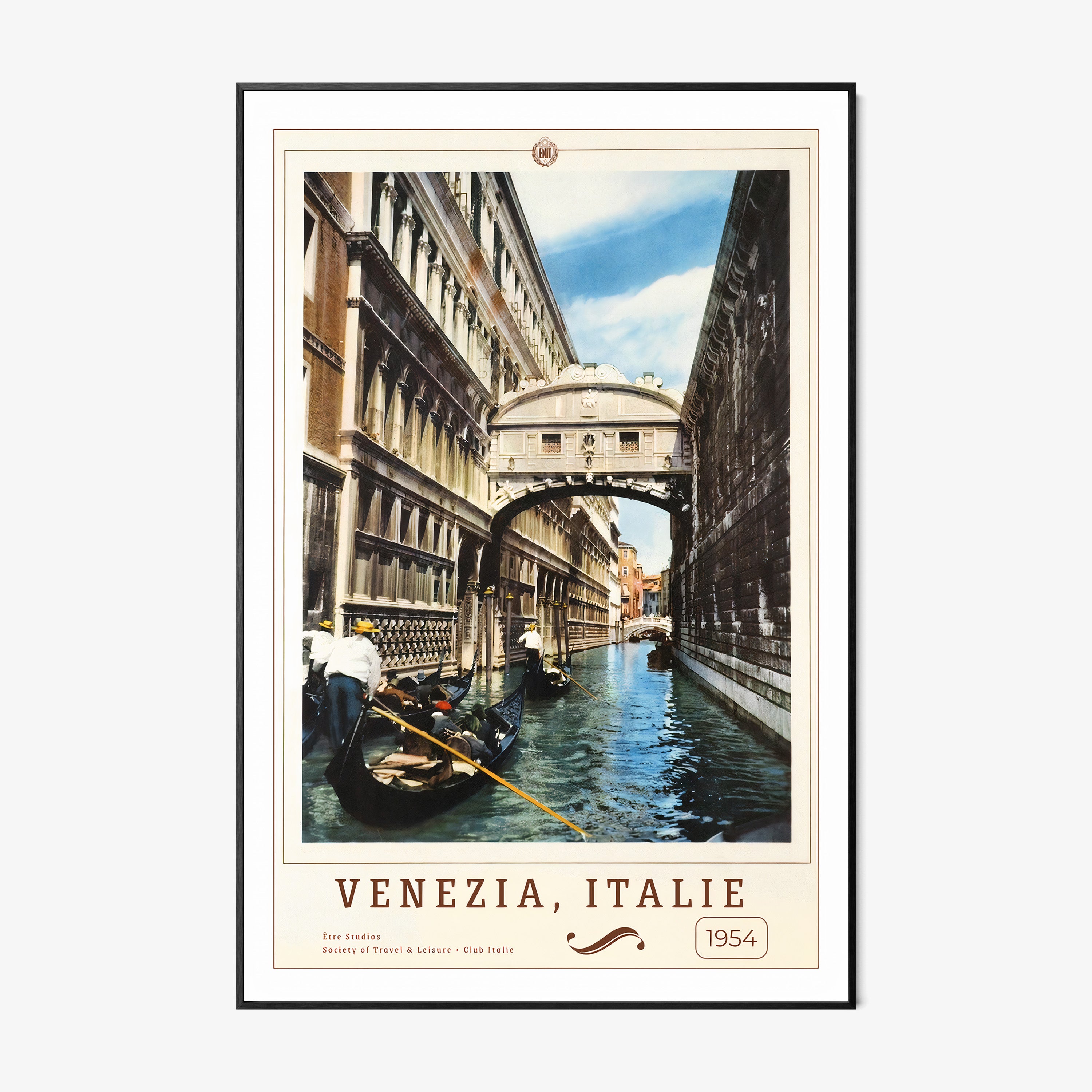 Framed poster of people on boats in a canal in between buildings with the text "Venezia, Italie" in large hanging on a wall with a light background