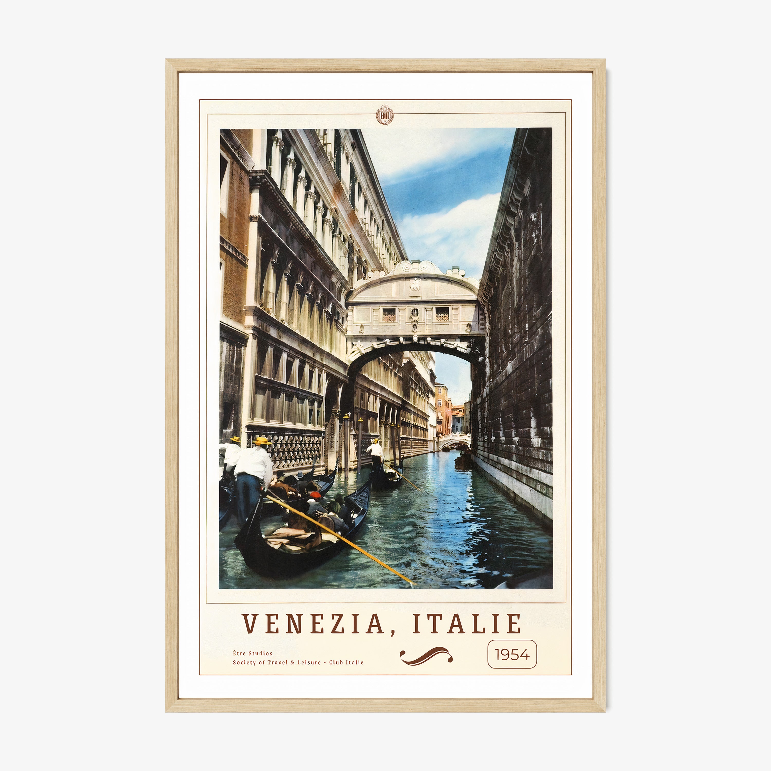 Framed poster of people on boats in a canal in between buildings with the text "Venezia, Italie" in large hanging on a wall with a light background