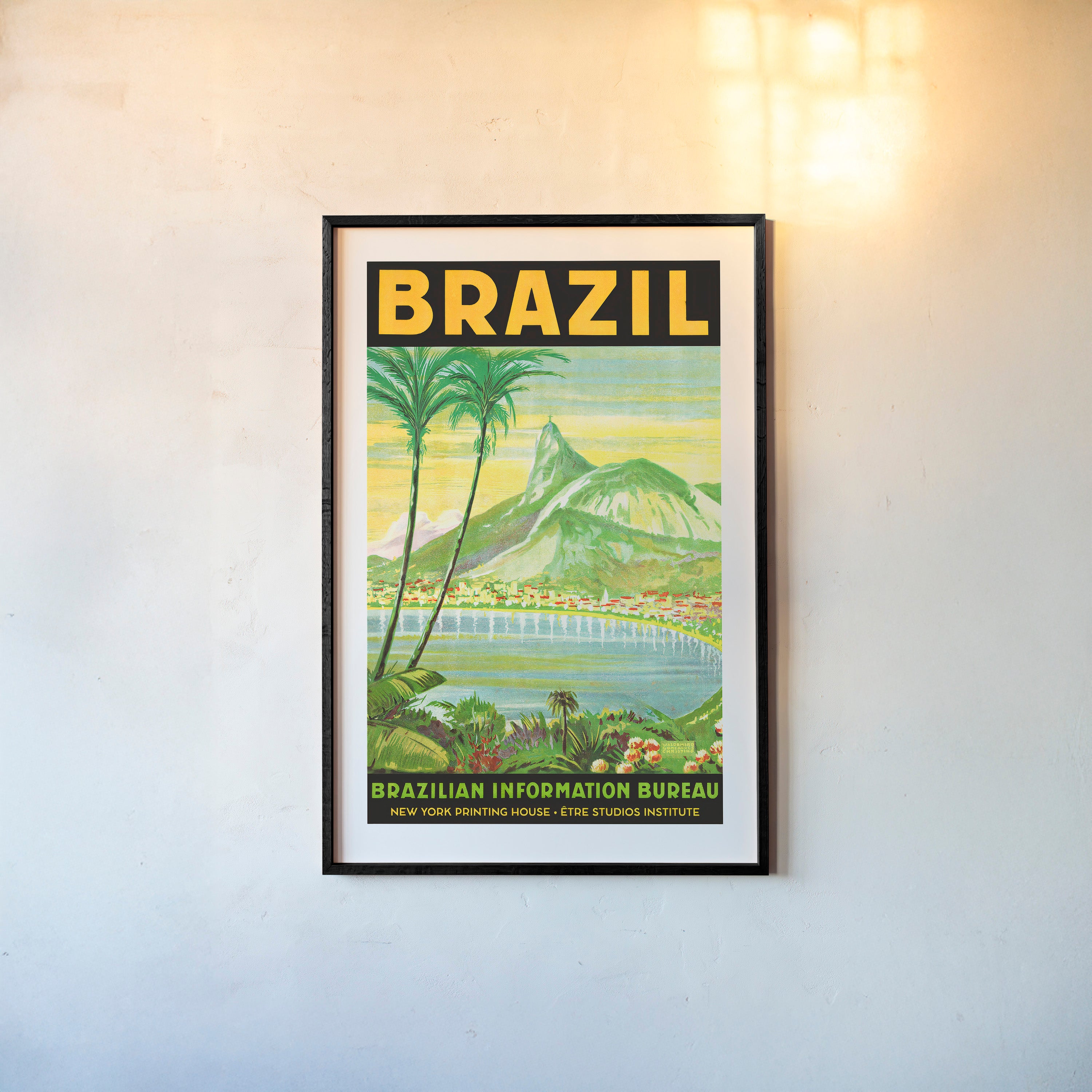 Framed poster of a waterfront with mountains in the background and the words "Brazil" in large letters at the top sitting on a light background