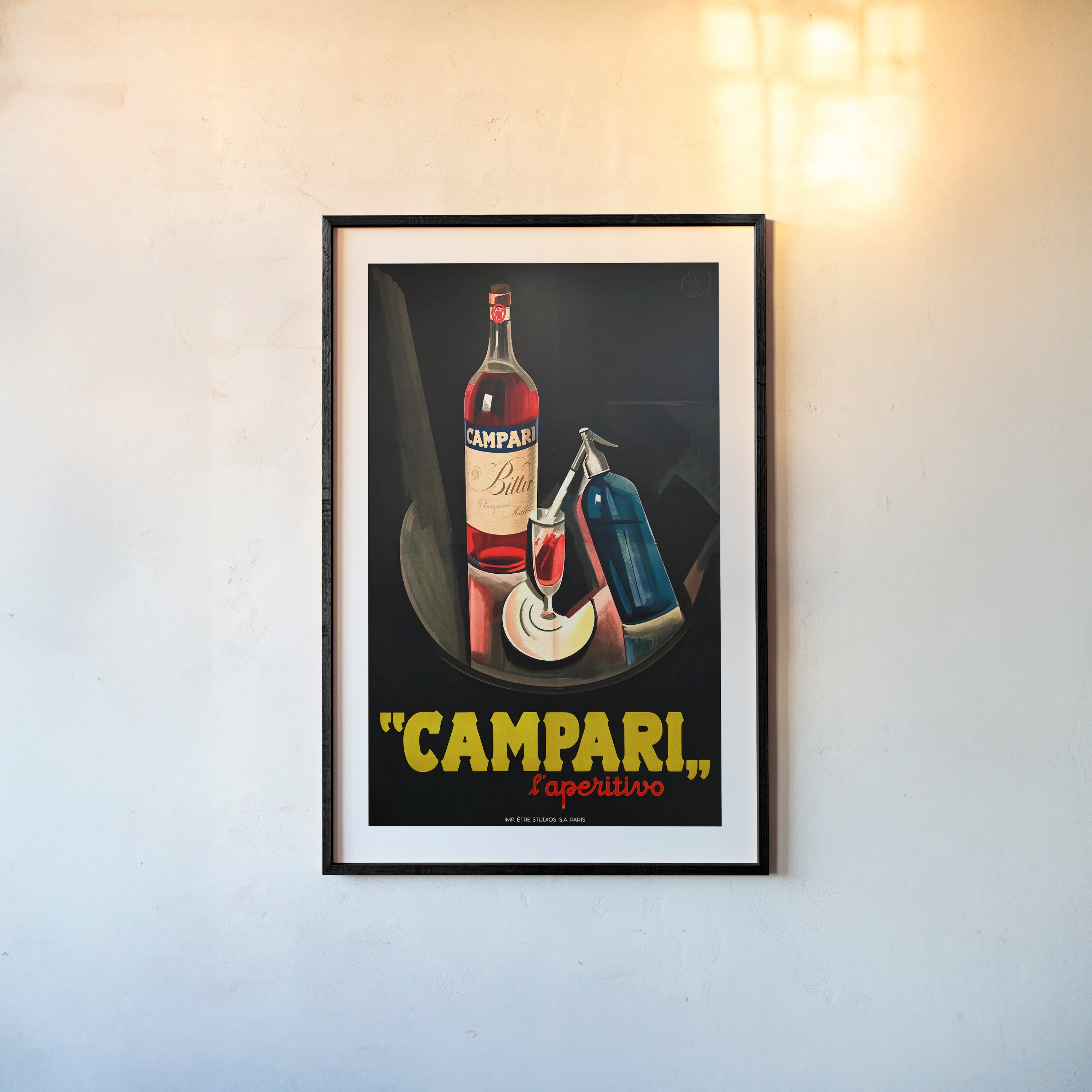 A framed poster features "Campari" with a bottle in the background