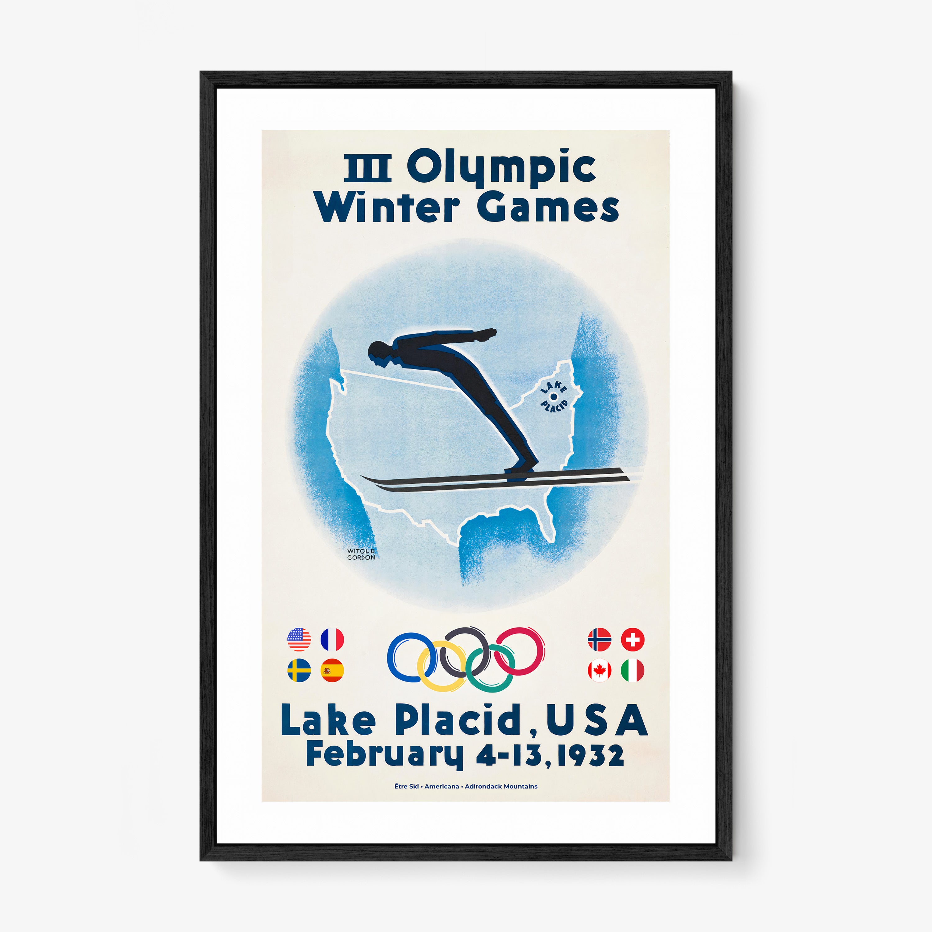 Framed poster of a skier with the United States map in the background and information on the 1932 Lake Placid winter olympic games hanging on a wall with a light background