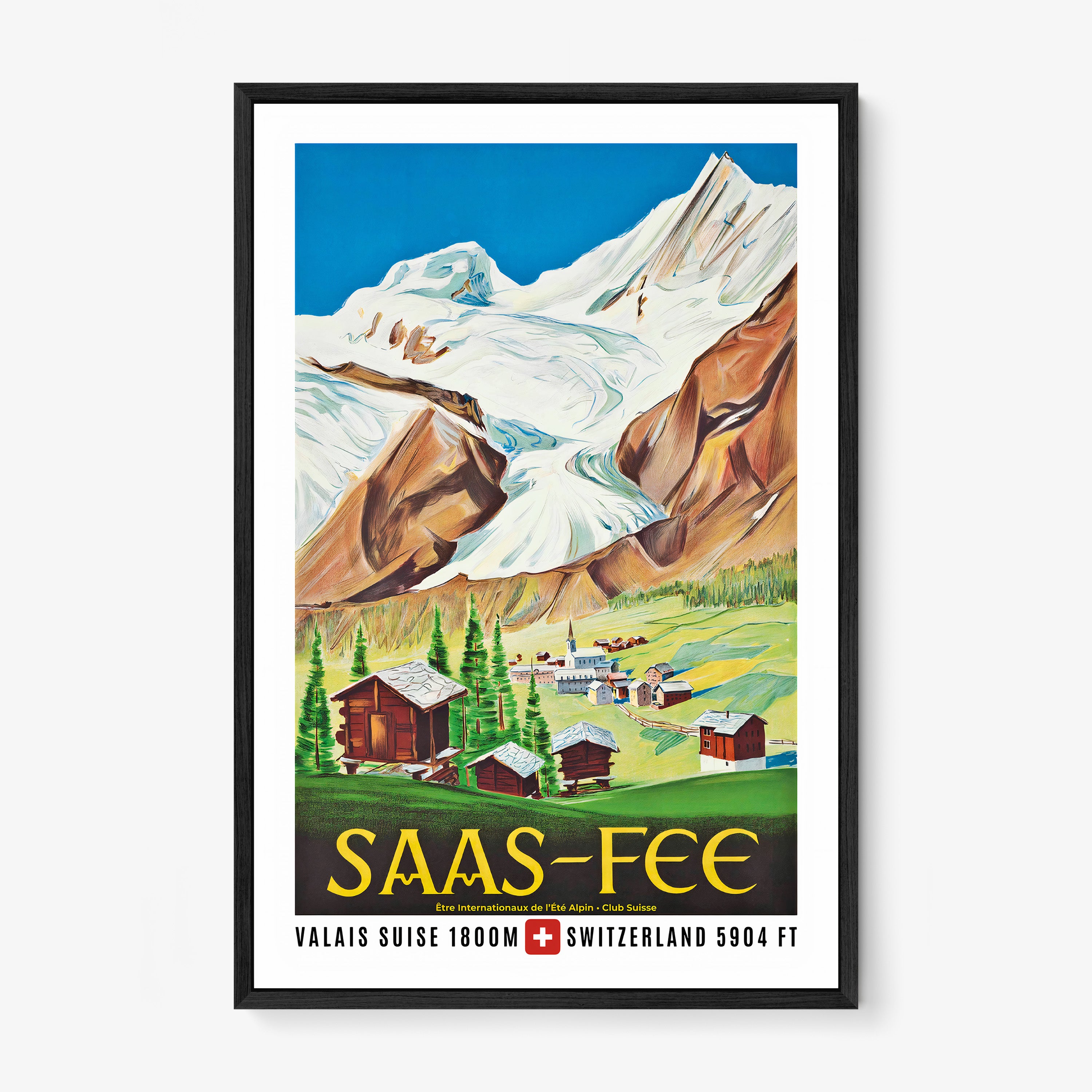 Framed poster of a large mountain with a small town shown at the base of it with the text "Saas-Fee" at the bottom hanging on a white background