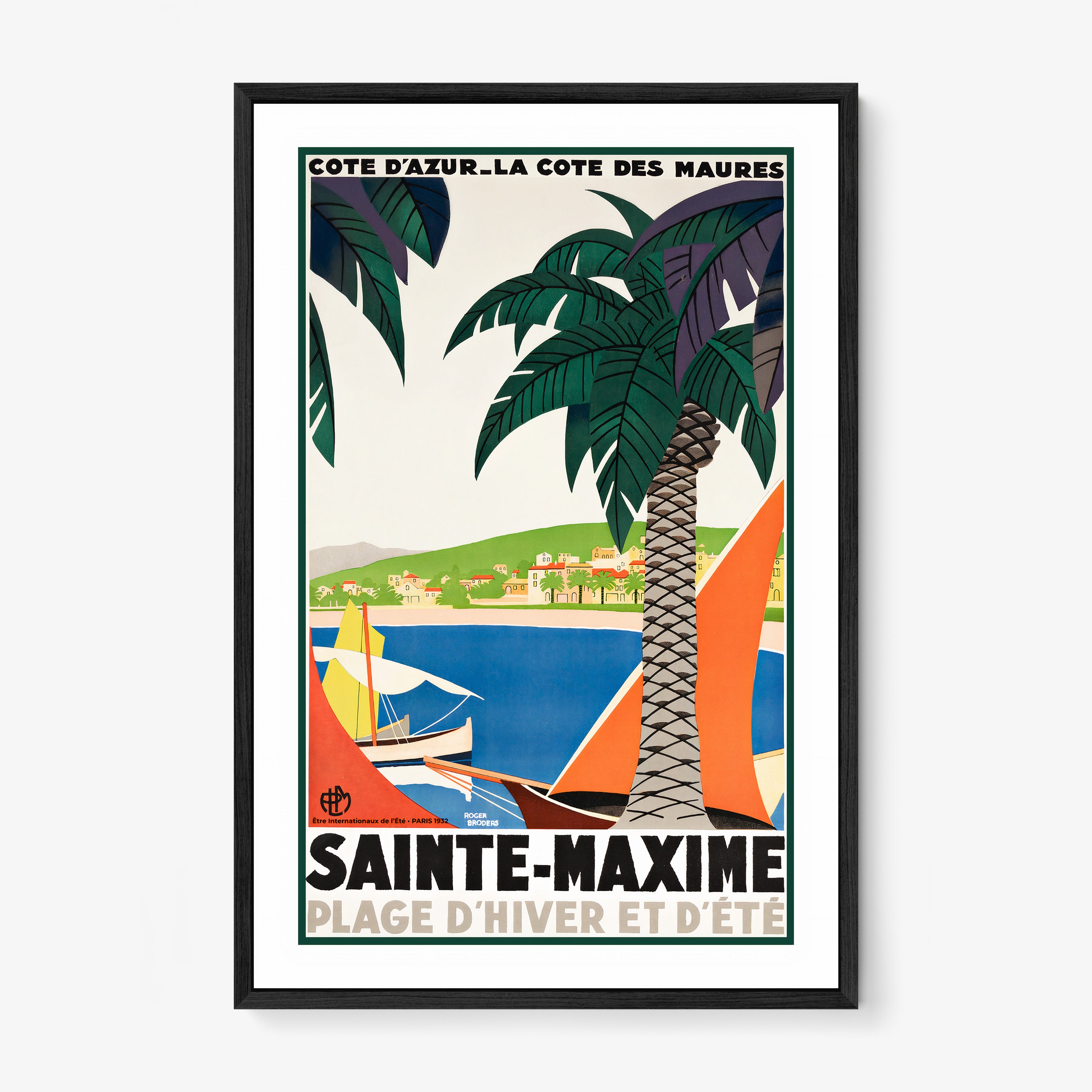 Framed poster featuring sailboats on a blue sea surrounded by palm trees and a coastal village with the text "Sainte-Maxime" at the bottom hanging on a white background