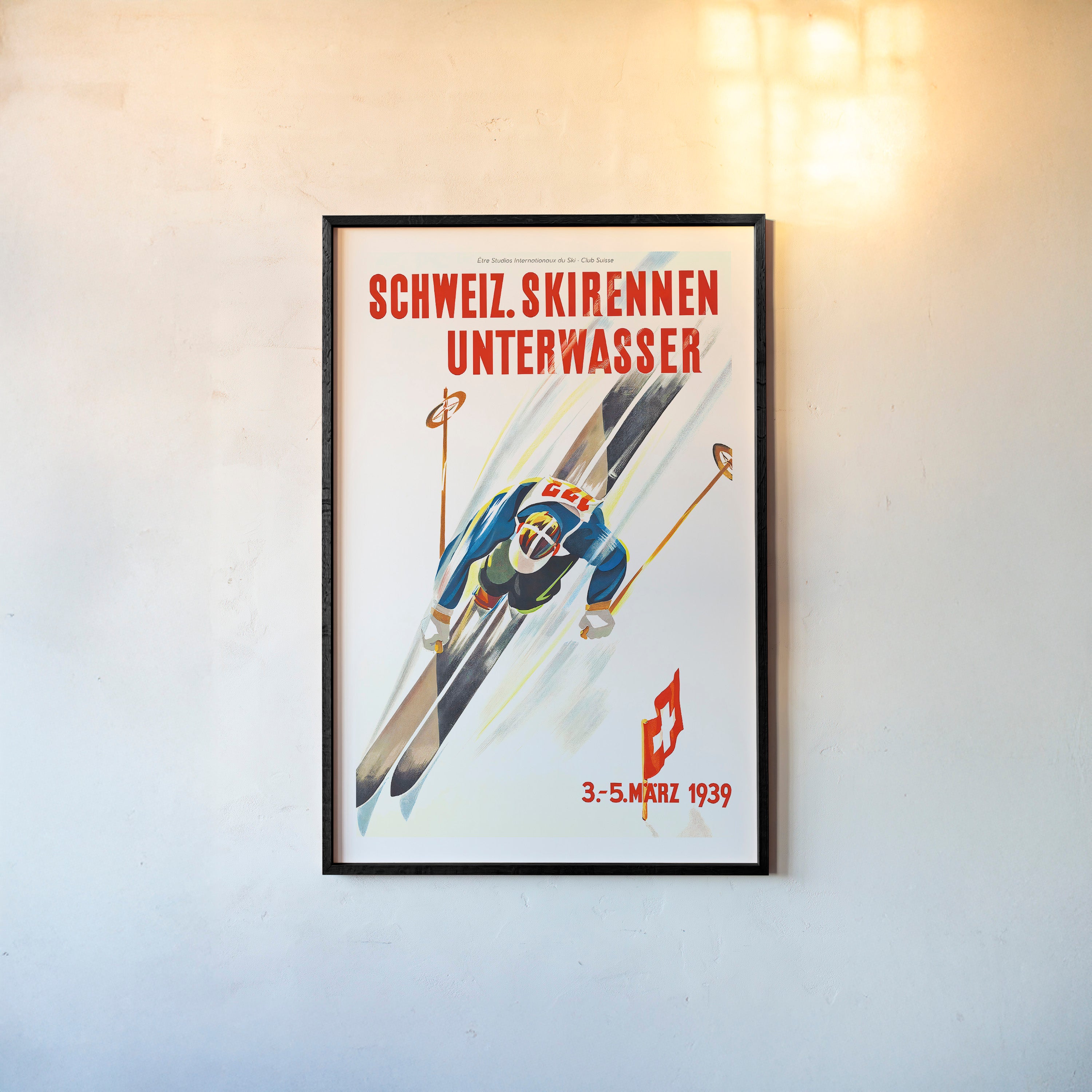 Framed poster of a skier taken from above hanging on a light backdrop