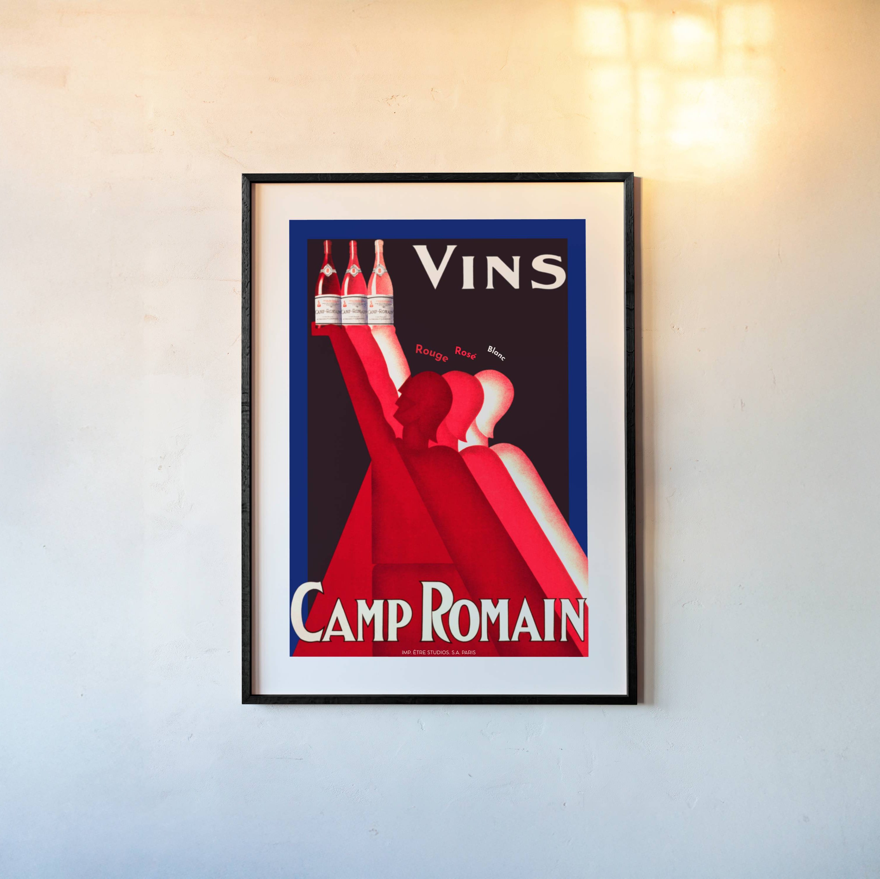 Framed vintage-style poster for Vins Camp Romain on a wall.