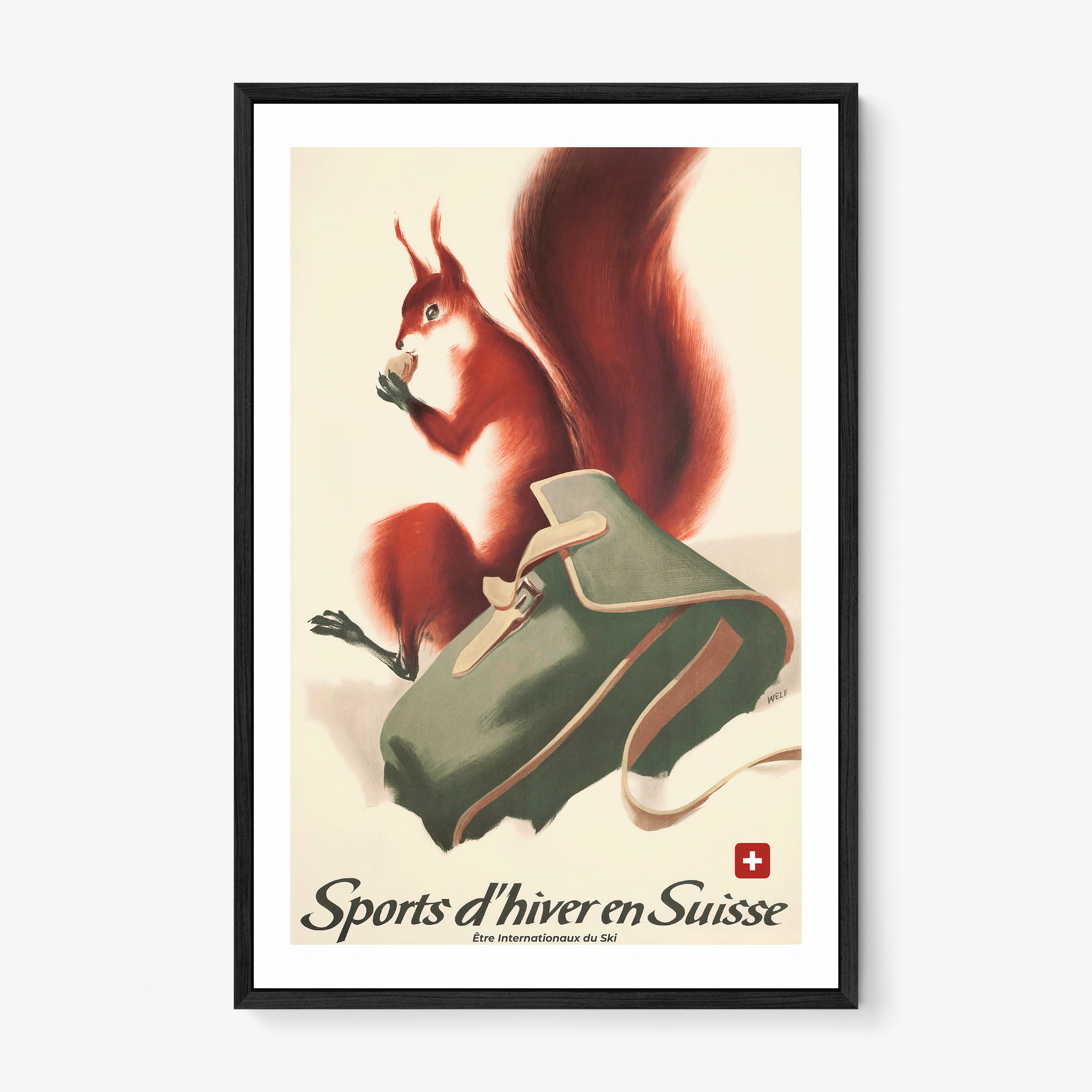 Framed poster of a fox next to a backpack in the snow with the text "Sports d'hiver en Suisse" at the bottom hanging on a wall with a light backdrop